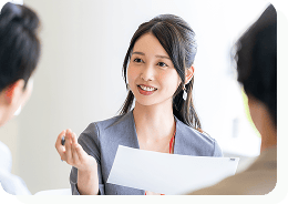 女性が男性2名と話をしている