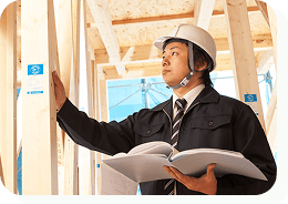 ヘルメットを被った男性が建設中の建物を確認している